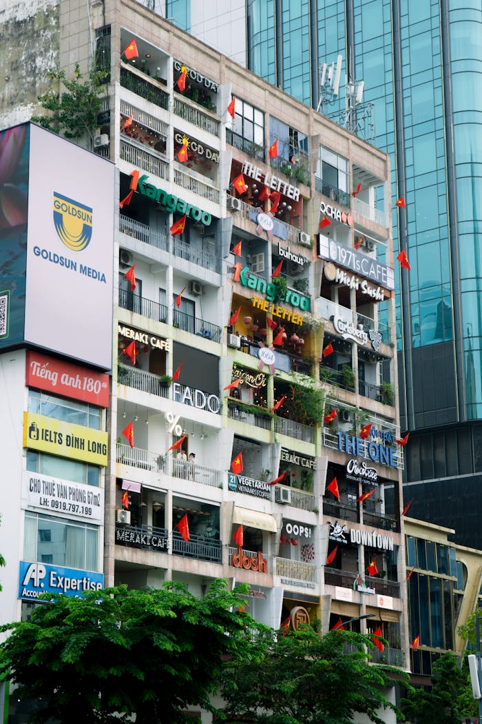 Mastering the First Impression: Your intriguing post title goes here High-rise building with colorful signage and Vietnamese flags in Ho Chi Minh City, Vietnam.